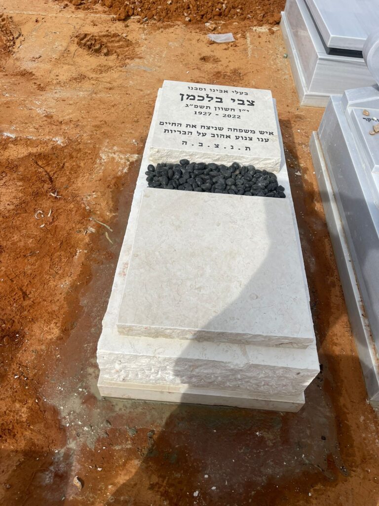 מצבה לבנה חדשה עם אבני זיכרון בחלקת בית העלמין