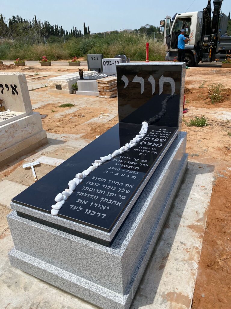מצבה שחורה מלוטשת מעוצבת בבית עלמין בזמן התקנתה