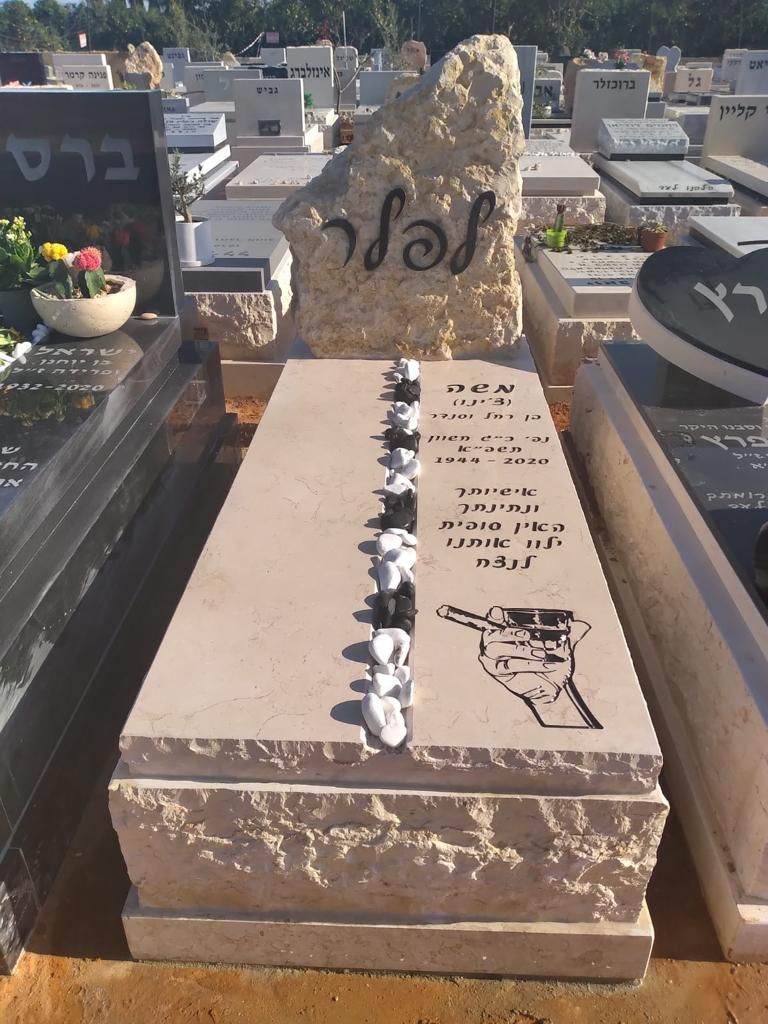 מצבה אבן בבית עלמין עם לוח משיש ואבני זיכרון מסודרות